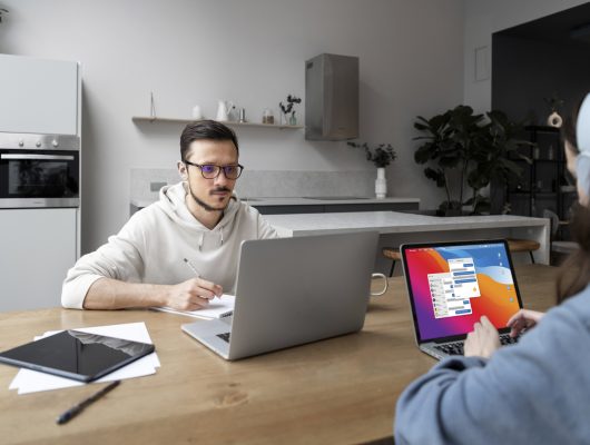 man woman working from home together desk